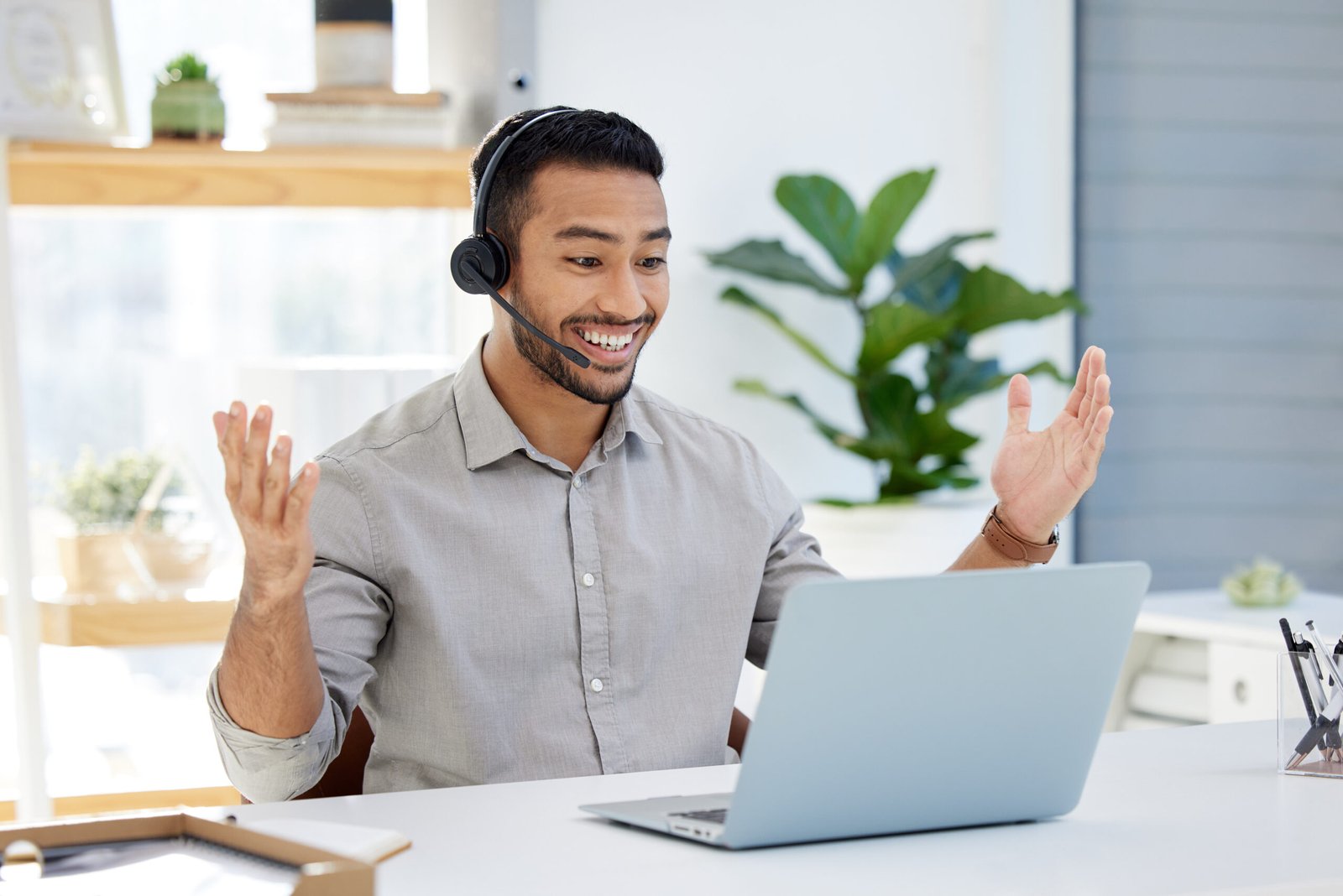 Service clientèle dédié d'Hexuvium : un professionnel heureux et engageant utilisant un geste de main pour saluer un client lors d'une session de support en ligne.
