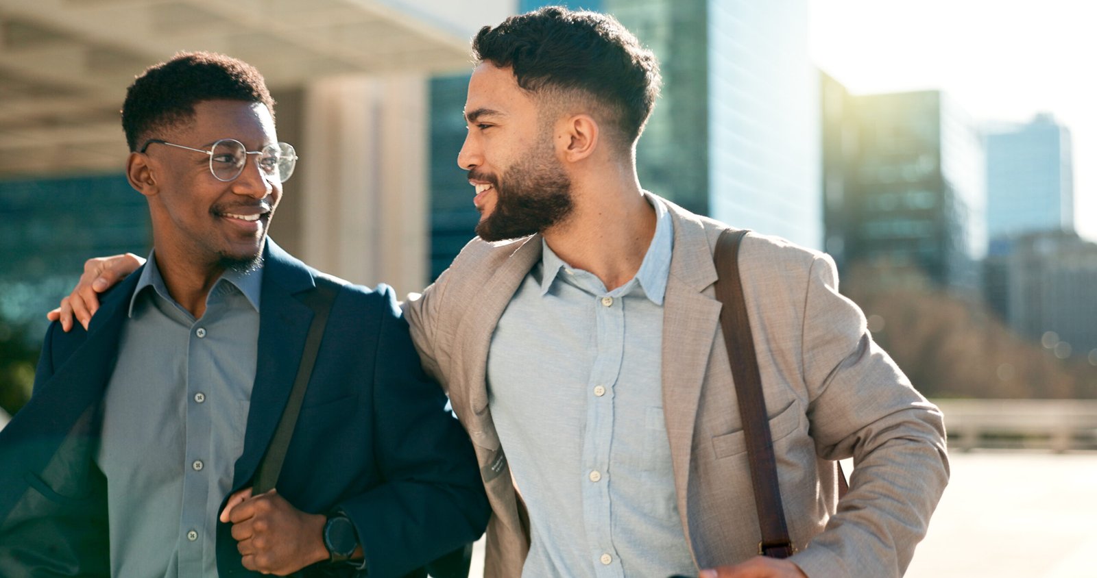 Un homme en souriant chaleureusement à un collègue lors d'une interaction amicale, illustrant l'importance des connexions personnelles dans les affaires.